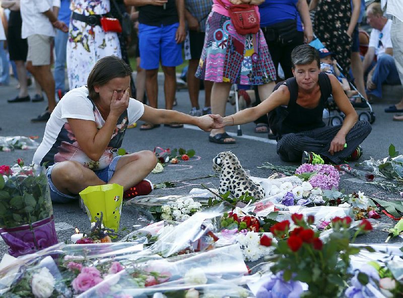 People mourn the victims of last week’s truck rampage Saturday at a memorial set up near one end of the famed Promenade des Anglais in Nice, France.