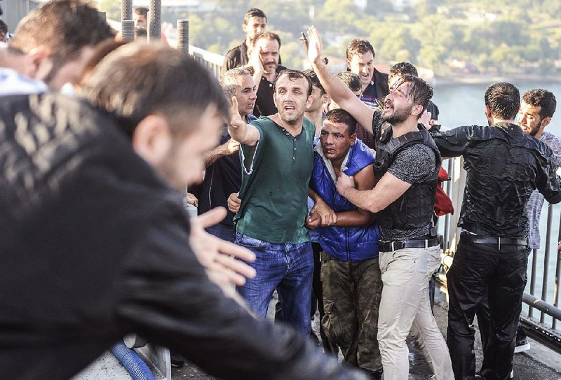 Protesters on the Bosporus bridge in Istanbul on Saturday seize a Turkish soldier (center, in blue), one of hundreds who surrendered after their failed coup attempt.
