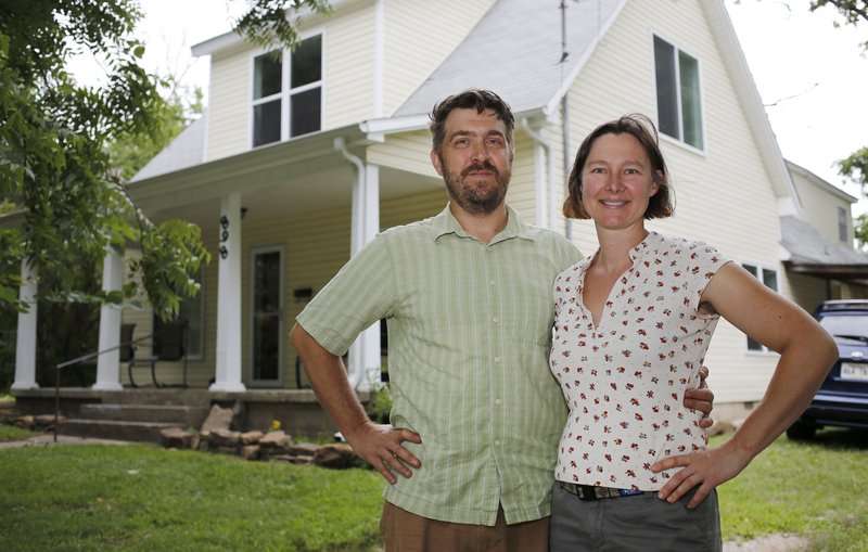 Jeff Hunt and Gretchen Schlump stand in front of her home Thursday on South Hill Avenue in Fayetteville she operates as a vacation home on Airbnb.