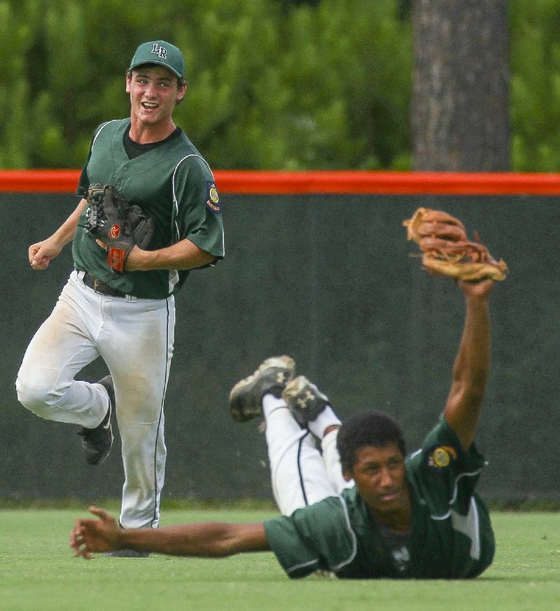Little Rock’s Dylan Chilcote (left) watches as teammate Markus Bracey makes a diving catch during their game
against Jacksonville on Monday in the American Legion state tournament. Little Rock pulled away for a 12-5 victory.