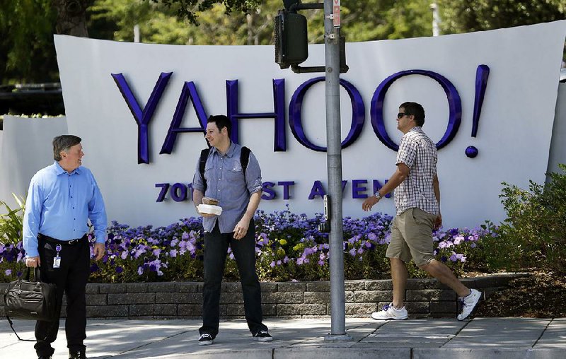 Pedestrians pass a Yahoo sign at company headquarters in Sunnyvale, Calif., in this file photo. Yahoo on Monday reported a second-quarter loss of $439.9 million.
