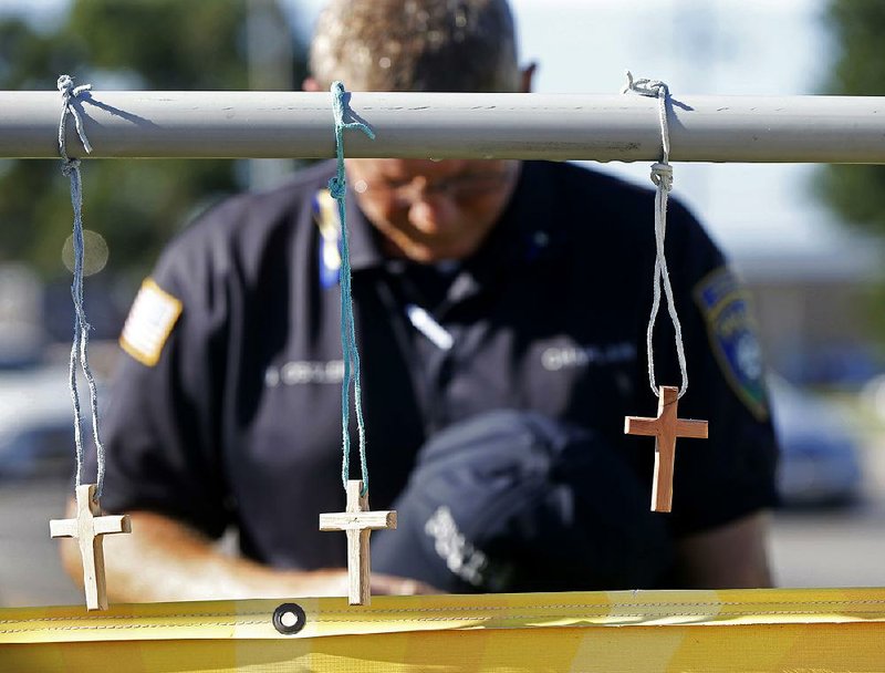 Millville, N.J., police chaplain Robert Ossler prays Monday in Baton Rouge at a makeshift memorial at the site where several law enforcement officers were killed in a shooting Sunday.