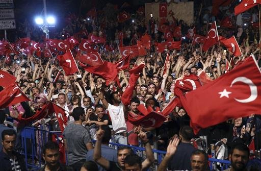 Supporters listen to Turkey's President Recep Tayyip Erdogan as he addresses them in front of his residence in Istanbul early Tuesday, July 19, 2016. 