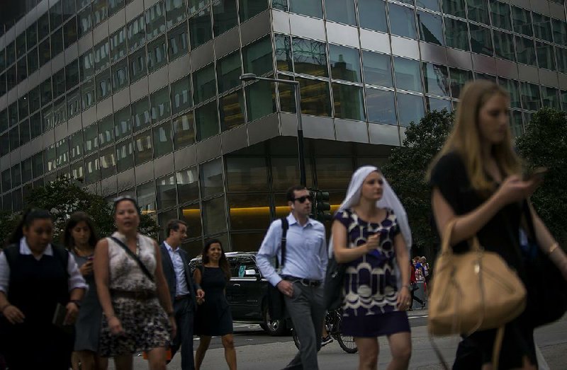Pedestrians pass Goldman Sachs Group Inc. headquarters in New York on July 13. The investment bank on Tuesday reported a second-quarter profit of $1.63 billion.