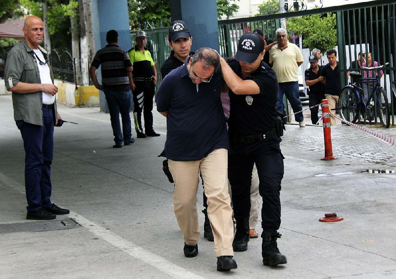 Police officers detain Turkish Adm. Atilla Demirhan and other military personnel Tuesday in the town of Mersin as the government widened its crackdown on suspected coup plotters.