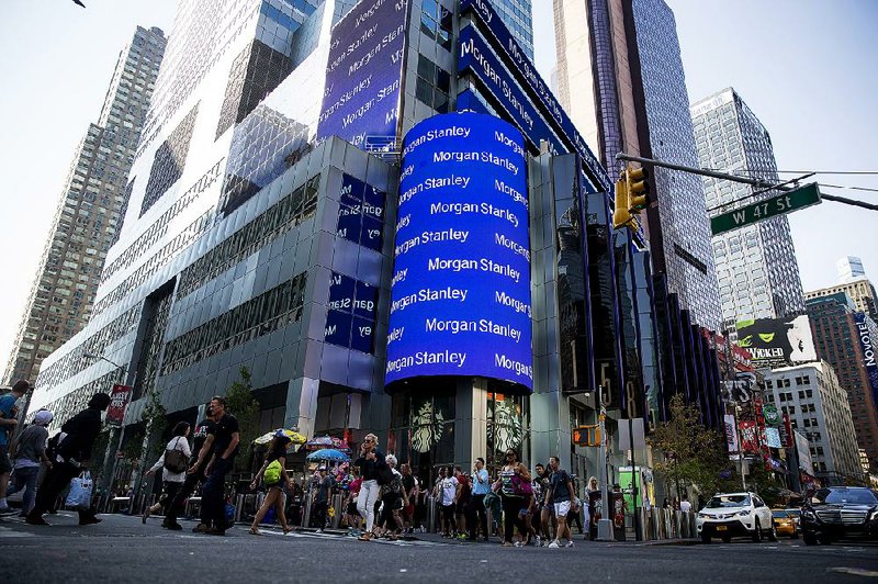 Pedestrians pass in front of Morgan Stanley’s headquarters in New York on July 12. The bank’s net income fell 5 percent to $1.58 billion in the second quarter.