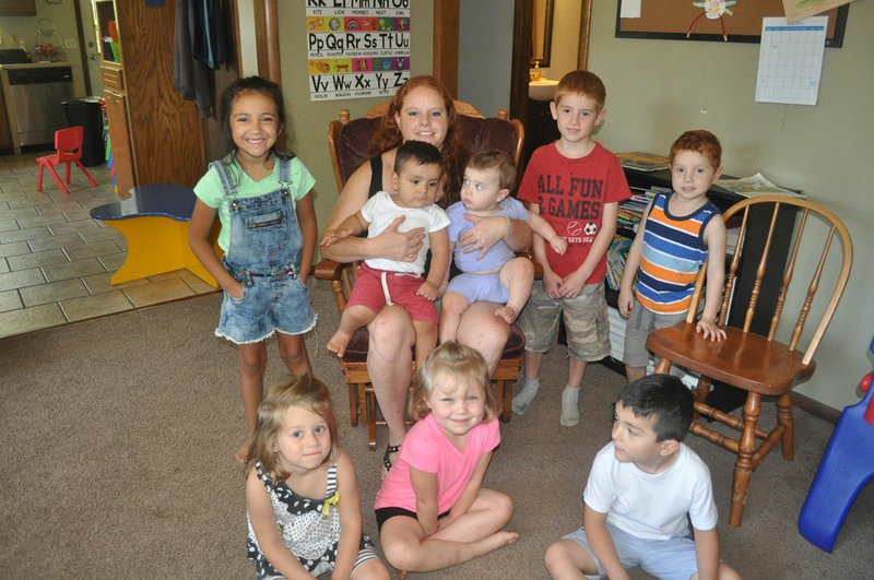 RACHEL DICKERSON/MCDONALD COUNTY PRESS Allie Peck, center, is surrounded by children who attend her daycare, Stepping Stones, in Noel.
