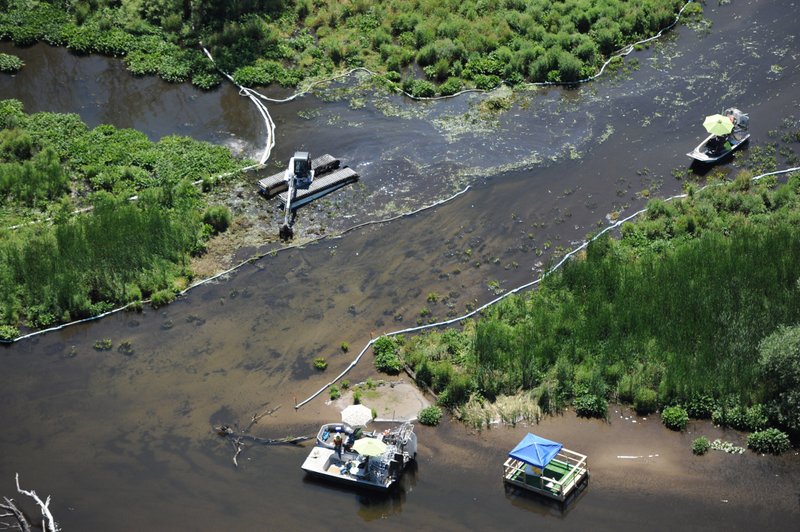 In a July 13, 2011 file photo, cleanup work continues on the Kalamzoo River almost a year after a spill near Marshall, Mich. Enbridge Energy Partners will pay a $61 million penalty for the costliest inland oil spill in U.S. history under an agreement with federal officials. 