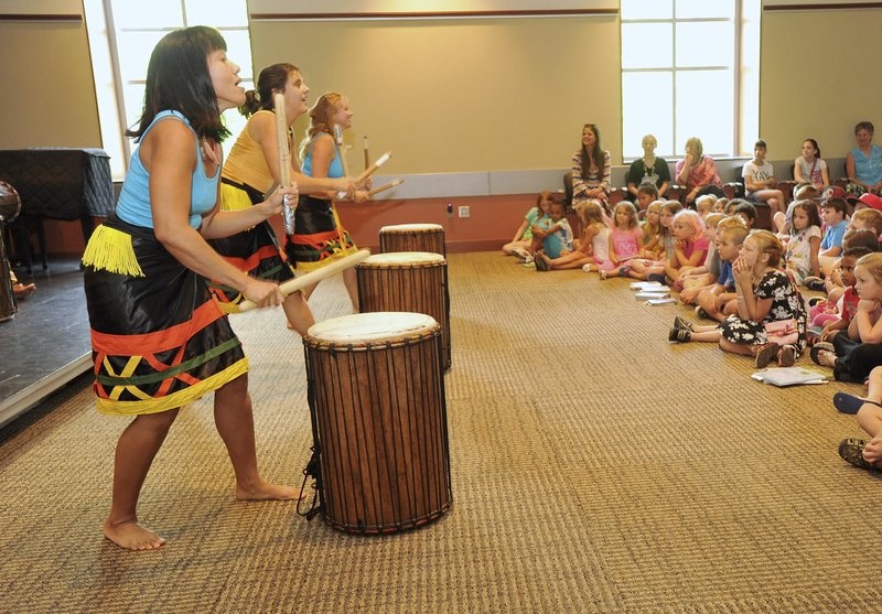 NWA Democrat-Gazette/MICHAEL WOODS &#8226; @NWAMICHAELW Nee Karas (from left), Margot Jackson and Gianella Edelen with Afrique Aya play the drums during their performance at the Fayetteville Public Library. Afrique Aya is a group of dancers and drummers dedicated to enjoying and sharing the music and culture of West Africa.