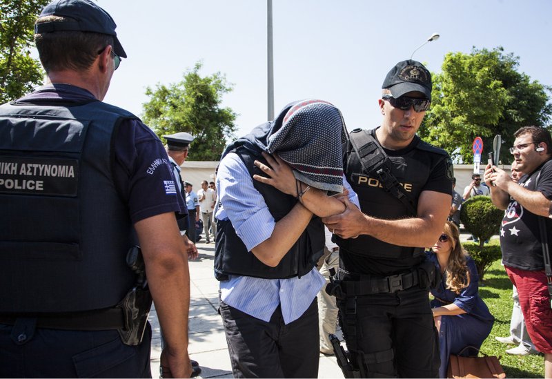 A Turkish military officer is transferred to a court hall in the city of Alexandroupolis, northern Greece, Thursday, July 21, 2016. Eight Turkish military personnel who fled to Greece a board a helicopter during an attempted coup in their country are testifying in court during their trial on charges of entering Greece illegally. Turkey is seeking their return to stand trial for participation in Friday&#x2019;s coup attempt. The eight deny any involvement and have applied for asylum, saying they fear for their lives if returned. (Antonis Pasvantis/InTime News via AP)