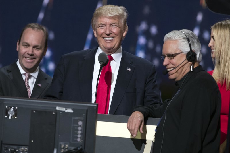 Republican presidential candidate Donald Trump, center, smiles as he talks with production crew during a walk through in preparation for his speech at the Republican National Convention, Thursday, July 21, 2016, in Cleveland.