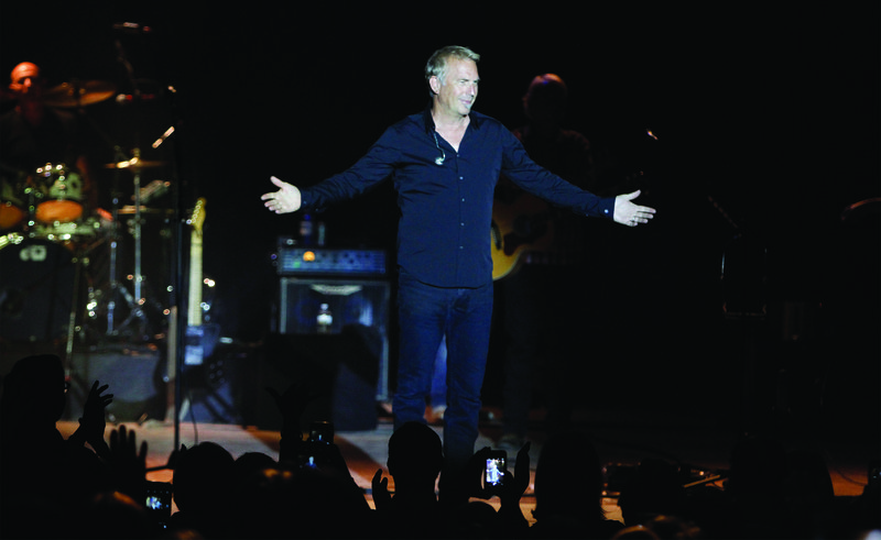 Costner: Kevin Costner waves to the crowd before taking the stage at the El Dorado Auditorium with his band, 'Kevin Costner and Modern West" on Friday.