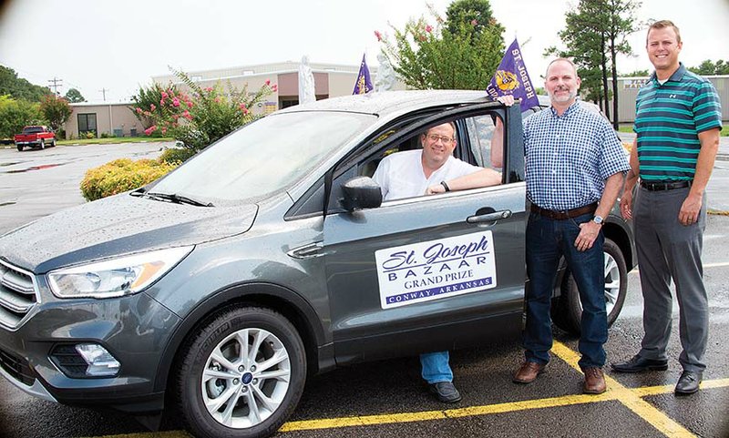 Randy Kordsmeier, from left; Jason Covington, chairman of the St. Joseph Catholic School Bazaar Executive Committee; and John Scherrey pose with the bazaar’s grand prize, a 2017 Ford Escape. The 104th bazaar is scheduled for Aug. 5 and 6 at the school in Conway. Raffle tickets are being sold for the vehicle, which will be given away at the close of the bazaar.