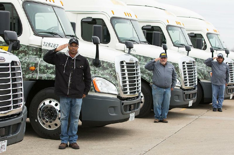 Veterans John Smallwood (from left), Daniel Byers and Louis Salas salute while standing next to J.B. Hunt rigs. Many trucking companies are actively recruiting veterans.