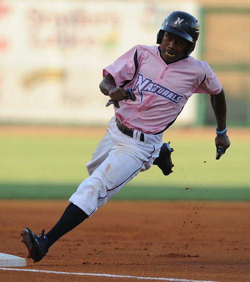 Northwest Arkansas Naturals center fielder Terrance Gore rounds third on his way to the plate Friday on a Corey Toups double against the Springfield Cardinals at Arvest Ballpark in Springdale.