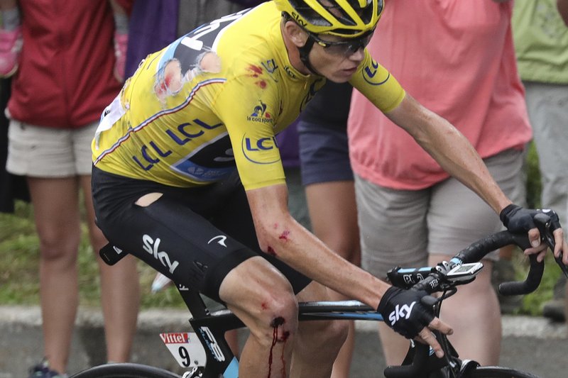 The Associated Press WEAR AND TEAR: A bleeding Chris Froome makes his way to the finish line after crashing in Stage 19 of the Tour de France on Friday. Despite the mishap, the British cyclist kept the overall leader's yellow jersey as the series heads to Paris for closing ceremonies Sunday.
