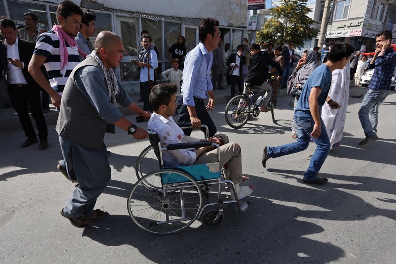 Afghans help an injured man at a hospital after an explosion struck a protest march, in Kabul, Afghanistan on Saturday. Witnesses in Kabul say that an explosion struck the protest march by members of Afghanistan’s largely Shiite Hazara ethnic minority group, demanding that a major regional electric power line be routed through their impoverished home province.