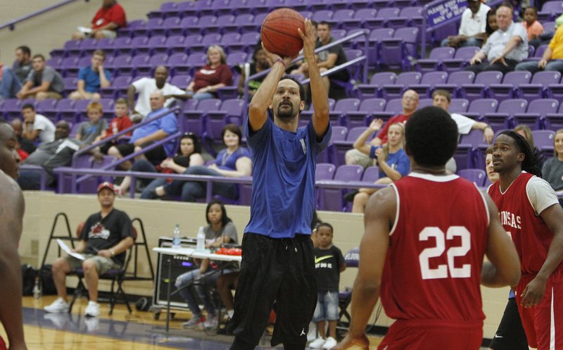 Former El Dorado girls basketball coach Stephen Harshaw takes a jump shot against the Arkansas Razorback alumni. Harshaw played for the El Dorado Police Department's team in a benefit game Saturday night at Wildcat Arena.