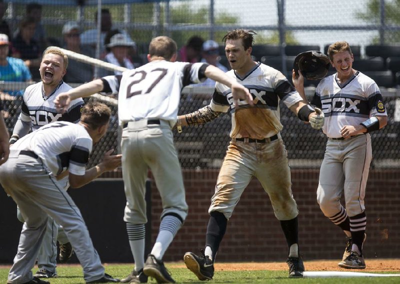 Bryant’s Austin Kelly (center) celebrates his home run with teammates during the Blacksox’s 10-0 victory over Texarkana during the American Legion AAA state tournament Saturday. The teams will play again today at noon for the title.