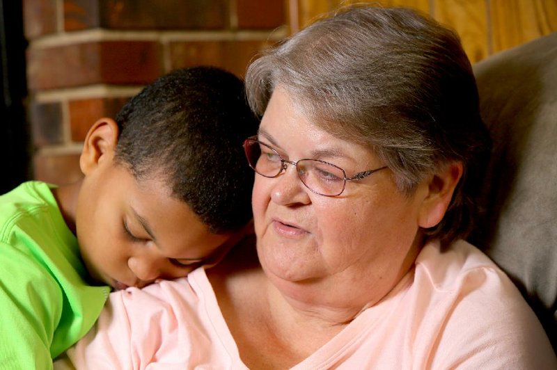 Jaydyn Cornelius, 8, snuggles with grandmother Cheryle Cornelius at their home near Blevins in Hempstead County. Cheryle Cornelius and her husband, Carl, adopted Jaydyn when he was 2.