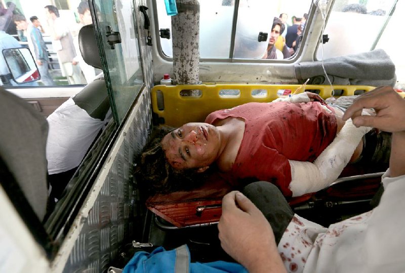 An injured man gets treatment Saturday inside an ambulance on a Kabul street.
