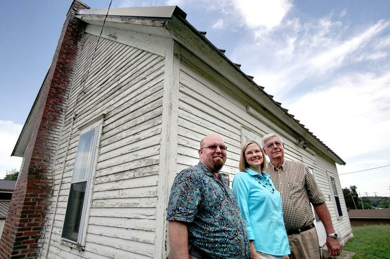 David Fox (from left), Kim Ferguson and Tom Farley stand outside a house in Sherwood that they’ve been researching.