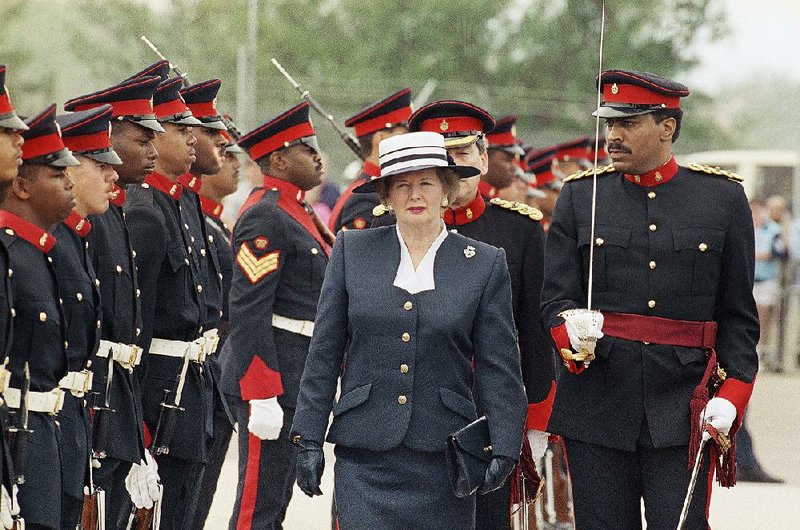 Margaret Thatcher, Britain’s fi rst female prime minister, clutches a handbag as she reviews the troops during a visit to Bermuda in April 1990.