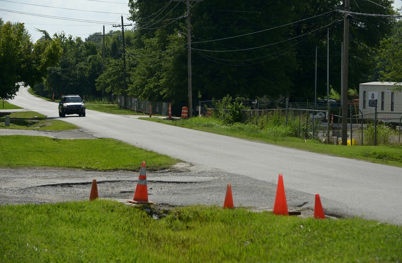 A vehicle drives on Southeast 8th Street on July 17 in front of the new 8th Street Market in Bentonville.