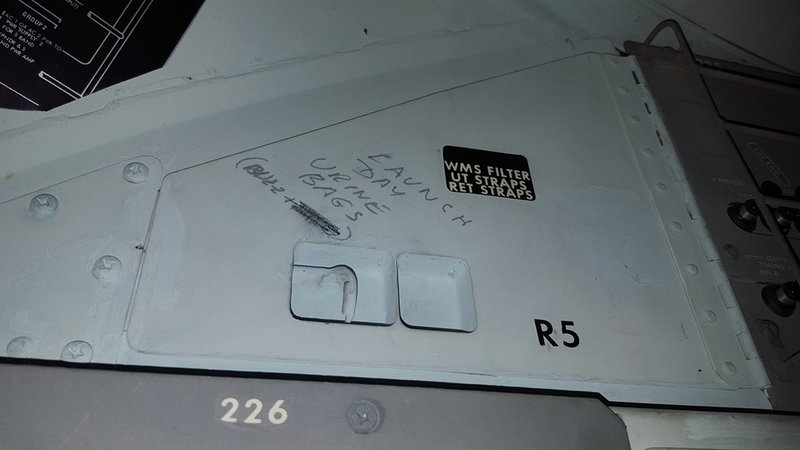 A door on the Apollo 11 capsule carries a note about “launch day urine bags.” 
