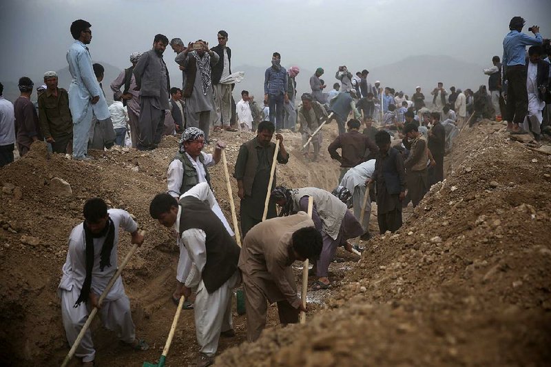 Afghan men dig graves Sunday in Kabul for victims of Saturday’s suicide bombing. Afghanistan held a national day of mourning Sunday.