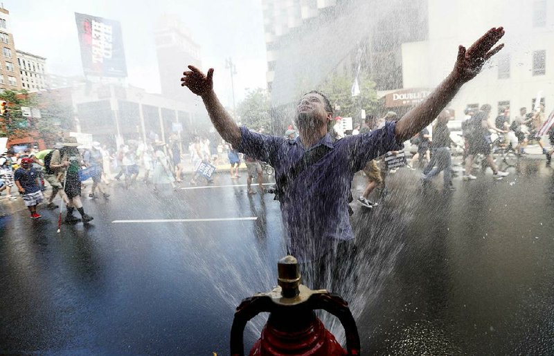 A supporter of Sen. Bernie Sanders cools off during a march in downtown Philadelphia on Sunday. The Democratic National Convention starts today in Philadelphia.