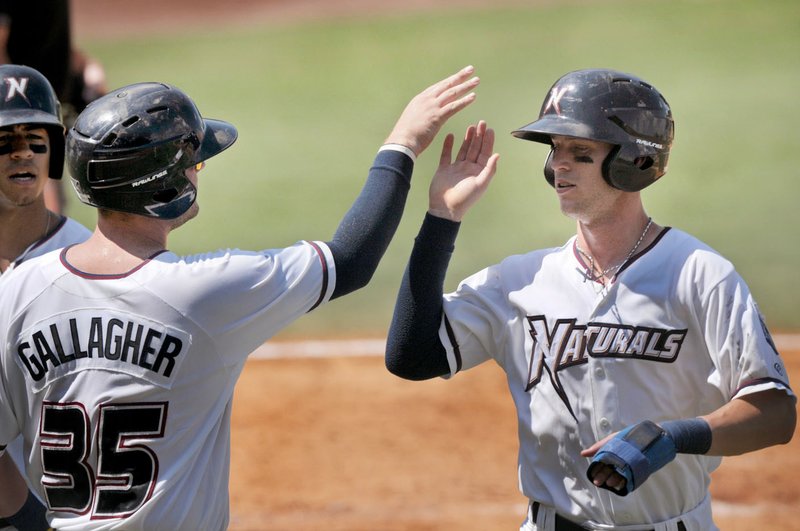 Cam Gallagher, Northwest Arkansas catcher, and Logan Moon, center fielder, celebrate Sunday after scoring on a single by Carlos Garcia (not pictured) in the 5th inning against Springfield at Arvest Ballpark in Springdale.