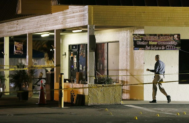 An investigator walks near the scene of a fatal shooting at Club Blu nightclub in Fort Myers, Fla., Monday, July 25, 2016. (Kinfay Moroti/The News-Press via AP)
