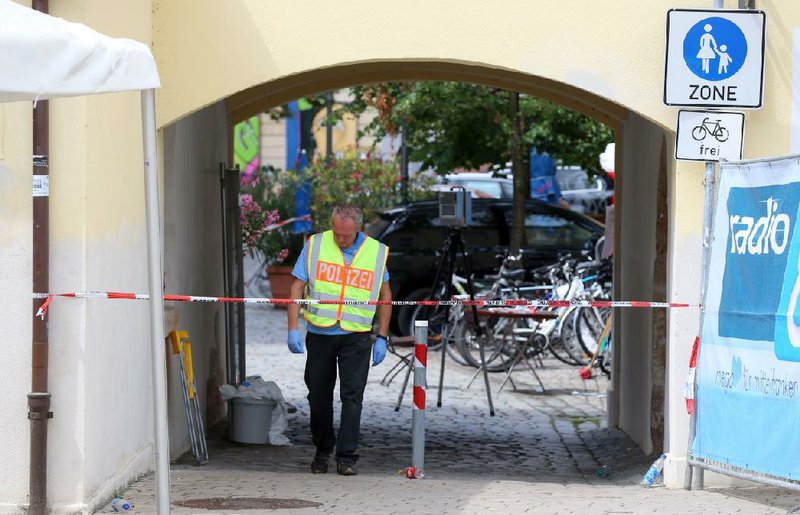A German police officer stands Monday near where a suicide attacker blew himself up in Ansbach, Germany.