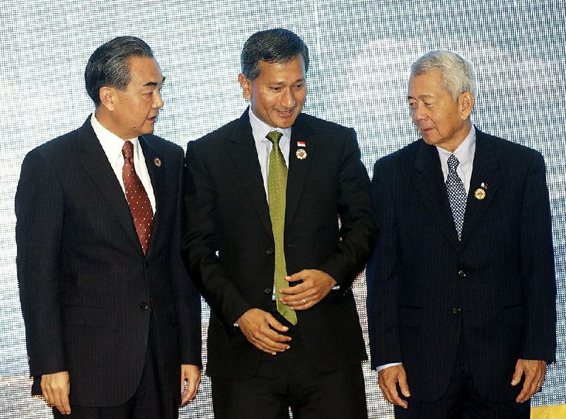 Chinese Foreign Minister Wang Yi (left) talks to Singapore’s Foreign Minister Vivian Balakrishnan and Philippine Foreign Secretary Perfecto Yasay Jr. during the Association of Southeast Asian Nations – China foreign ministers’ meeting in Vientiane, Laos, on Monday.