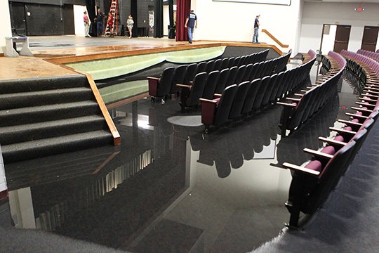 The Sentinel-Record/Richard Rasmussen WATER DAMAGE: Workers survey the water damage in the Lake Hamilton High School auditorium Monday after a pipe leak flooded areas of the school. Water pooled as deep as 12 inches in the front of the auditorium.