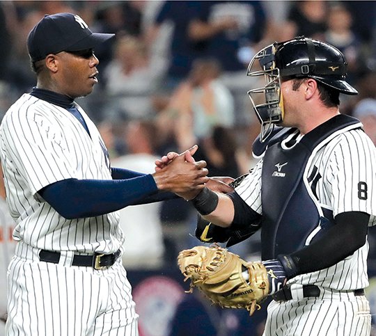 The Associated Press CUBAN MISSILE DEAL: New York Yankees relief pitcher Aroldis Chapman, left, shakes hands with catcher Austin Romine after the Yankees defeated the San Francisco Giants 3-2 Friday night in New York. Chapman was dealt to the Chicago Cubs on Monday.