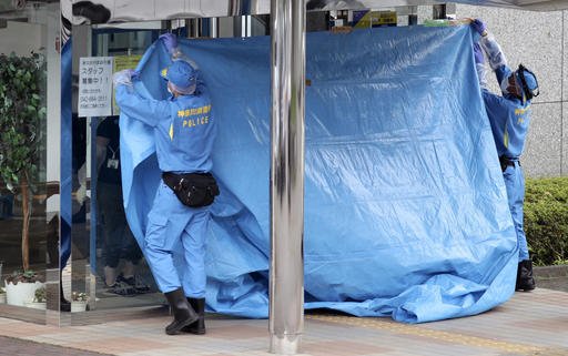 Police investigators cover the entrance of the Tsukui Yamayuri-en, a facility for the disabled where a number of people were killed and dozens injured in a knife attack, with a blue sheet in Sagamihara, outside Tokyo, on Tuesday, July 26, 2016.
