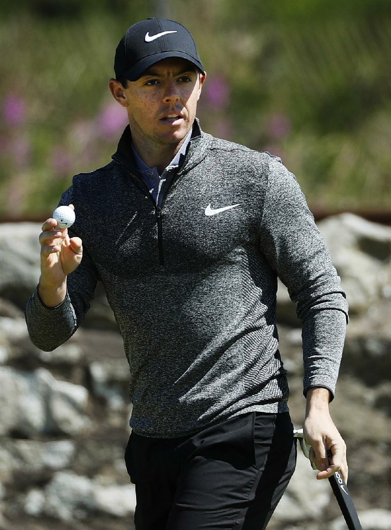 Rory McIlroy of Northern Ireland holds his ball up as he acknowledges spectators on the 11th green during the first round of the British Open Golf Championship at the Royal Troon Golf Club in Troon, Scotland, Thursday, July 14, 2016.