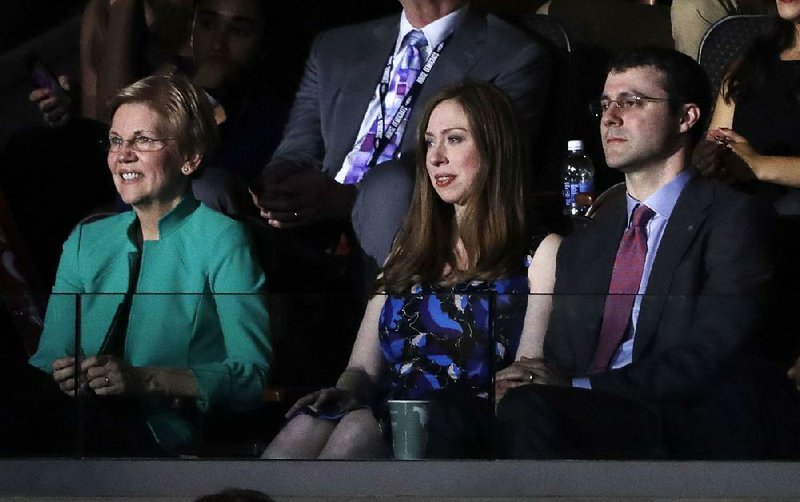 Sen. Elizabeth Warren of Massachusetts sits with Chelsea Clinton and her husband, Marc Mezvinsky, as former President Bill Clinton speaks Tuesday night at the Democratic convention.