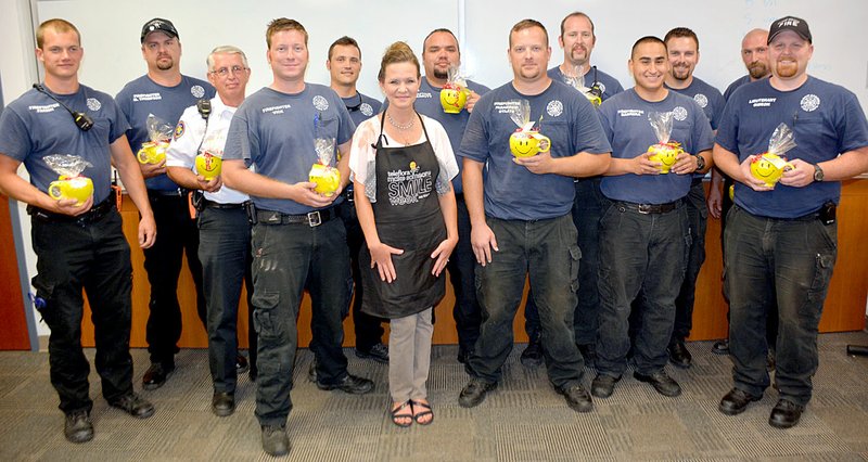 Janelle Jessen/Herald-Leader Melanie Pentacost, owner of Siloam Flowers and Gifts, presented Siloam Springs firefighters with 48 chocolate kiss arrangements as part of Teleflora&#8217;s Make Someone Smile Week.