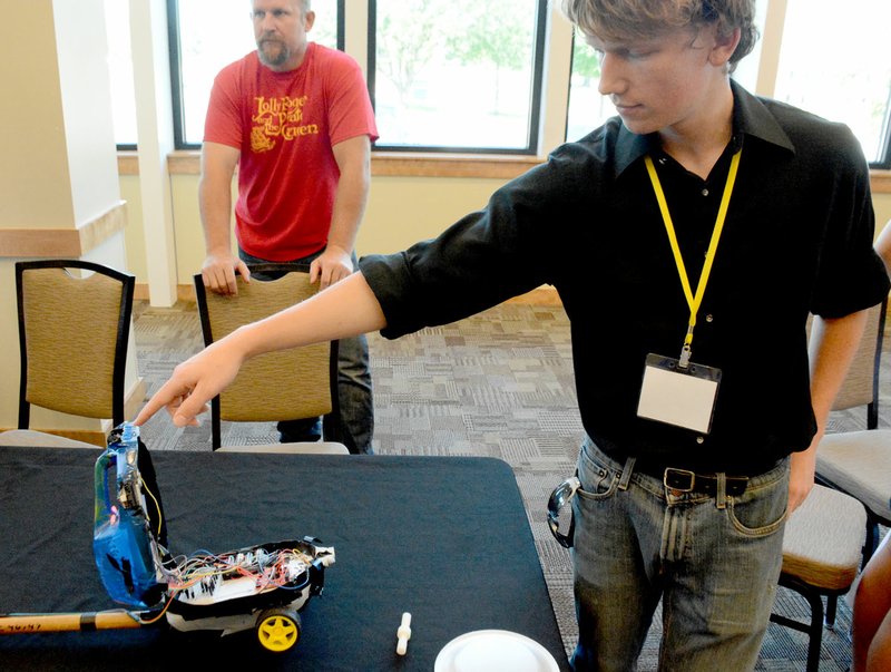 Michael Burchfiel/Herald-Leader Max Stoner, a student at the camp, demonstrated his project. As part of the camp, he built a device meant to stand in for a seeing eye dog by alerting the user when ledges or walls were near. He had to return the handle, because it belonged to a custodian&#8217;s broom.