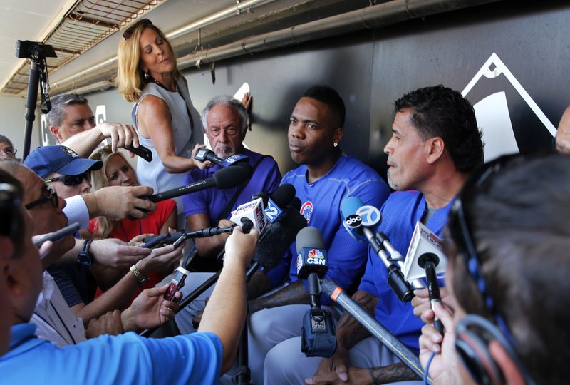 Chicago Cubs reliever Aroldis Chapman, center, listens to a question as he meets reporters before a baseball game between the Chicago White Sox and Cubs Tuesday, July 26, 2016, in Chicago.