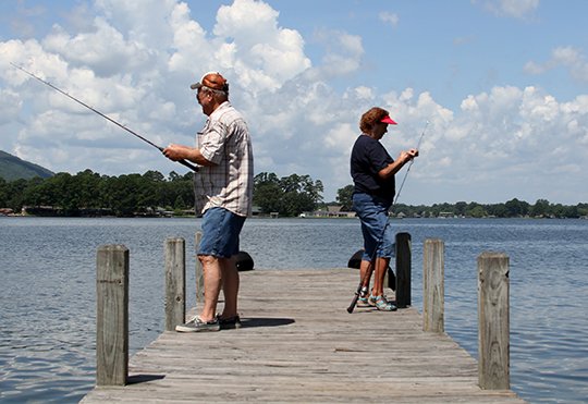 The Sentinel-Record/Max Bryan ANGLING AWAY: Walter, left, and Carol Jackson, of Pearcy, cast their lines off a dock at Andrew H. Hulsey State Fish Hatchery on Lake Hamilton on Tuesday.