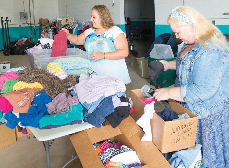 Autumn Hunter, left, director of A Step Forward, and Misty Lee-Black, warehouse manager, sort through piles of donated clothing in the White-Rodgers Wastewater Recycling Plant warehouse in Batesville. A Step Forward aims to provide temporary housing, career skills and necessities to families in need. The organization is working toward securing a home to serve as a shelter for up to four families.