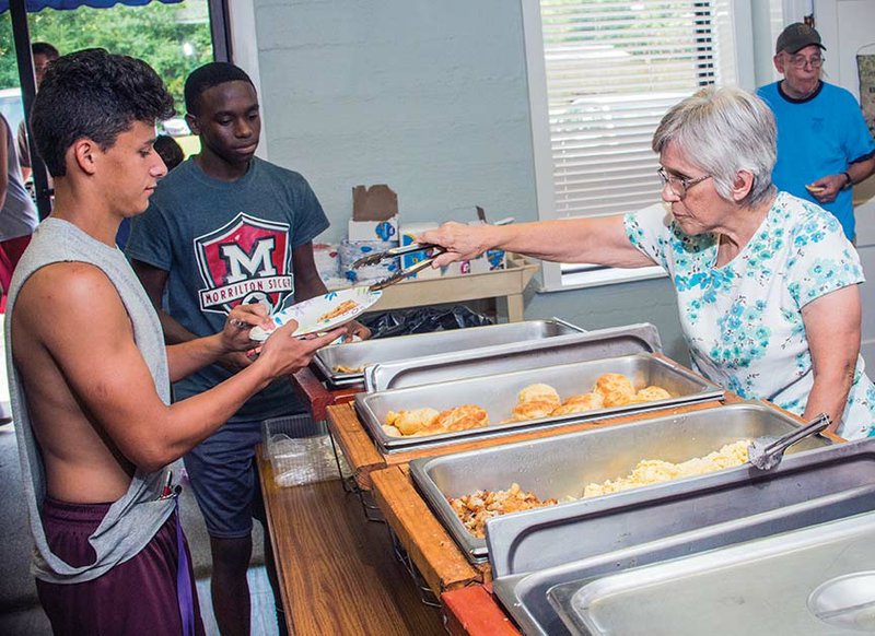 Nicki Suddeth, right, serves Morrilton football player C.J. Gonzales, 17, while Kyren Gilreath, 17, waits his turn at the free Summer Food Service Program at First Presbyterian Church in Morrilton. The program, in its third year, offers free breakfast from 8-9:30 a.m. Monday through Friday, and the last day for the meal will be Aug. 12.