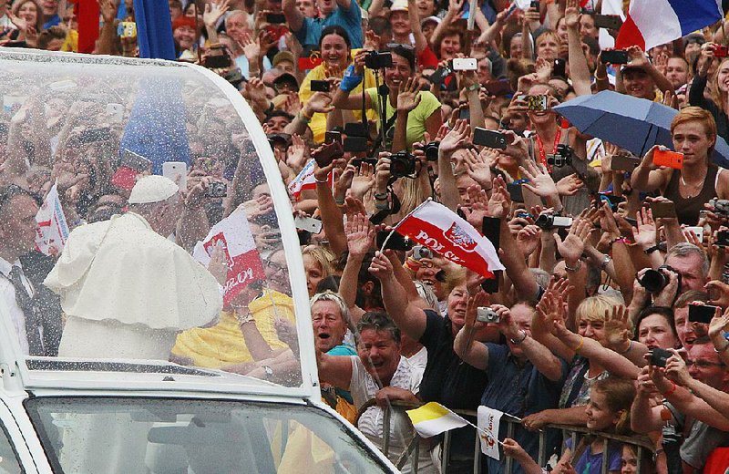 Pope Francis salutes the crowd Wednesday on his way to Wawel Castle in Krakow, Poland. 