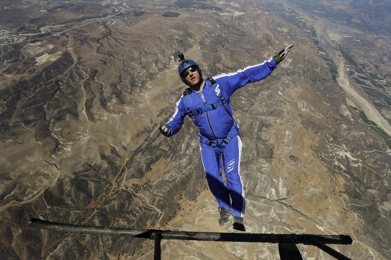 In this Monday, July 25, 2016 photo, skydiver Luke Aikins jumps from a helicopter during his training in Simi Valley, Calif. After months of training, this elite skydiver says he's ready to leave his chute in the plane when he bails out 25,000 feet above Simi Valley on Saturday. That's right, no parachute, no wingsuit and no fellow skydiver with an extra one to hand him in mid-air. (AP Photo/Jae C. Hong)
