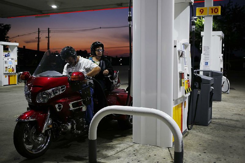 A customer stops to fuel up a motorcycle at a Shell station in Louisville, Ky., on Wednesday. Royal Dutch Shell on Thursday reported a quarterly profit of $1.05 billion.