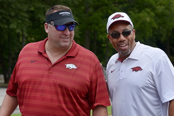 Bret Bielema (left), Arkansas head football coach, and Vernon Hargreaves, linebackers coach, talk on Friday July 29, 2016 during the NWA Razorback Club's 15th Annual Celebrity Golf Tournament at the Kingswood and Berksdale golf complex in Bella Vista.